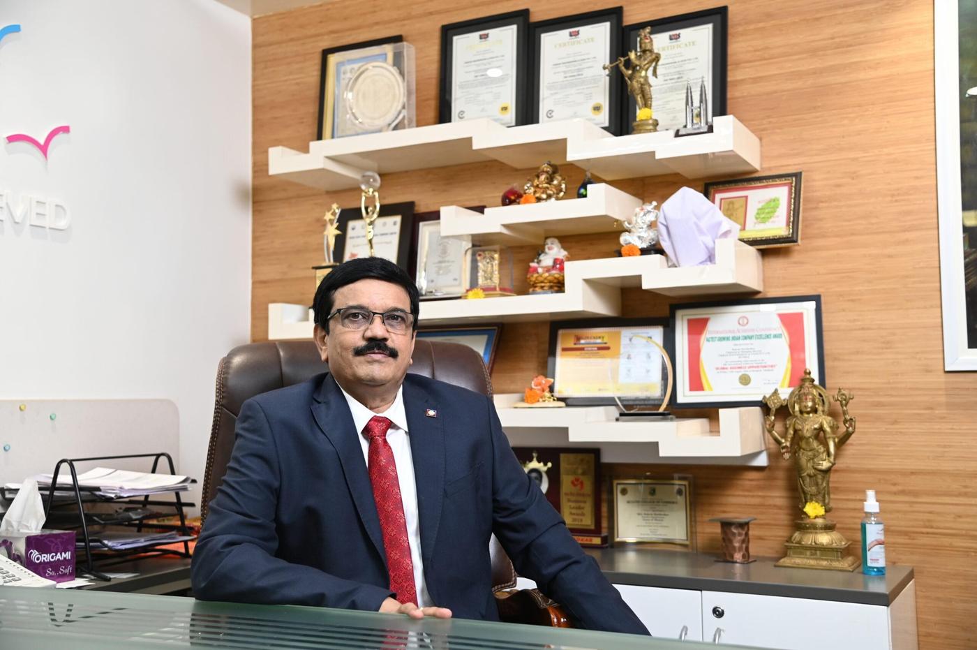 Rakesh Markhedkar at his office desk beside a display of citations Rakesh Markhedkar at his office desk beside a display of citations